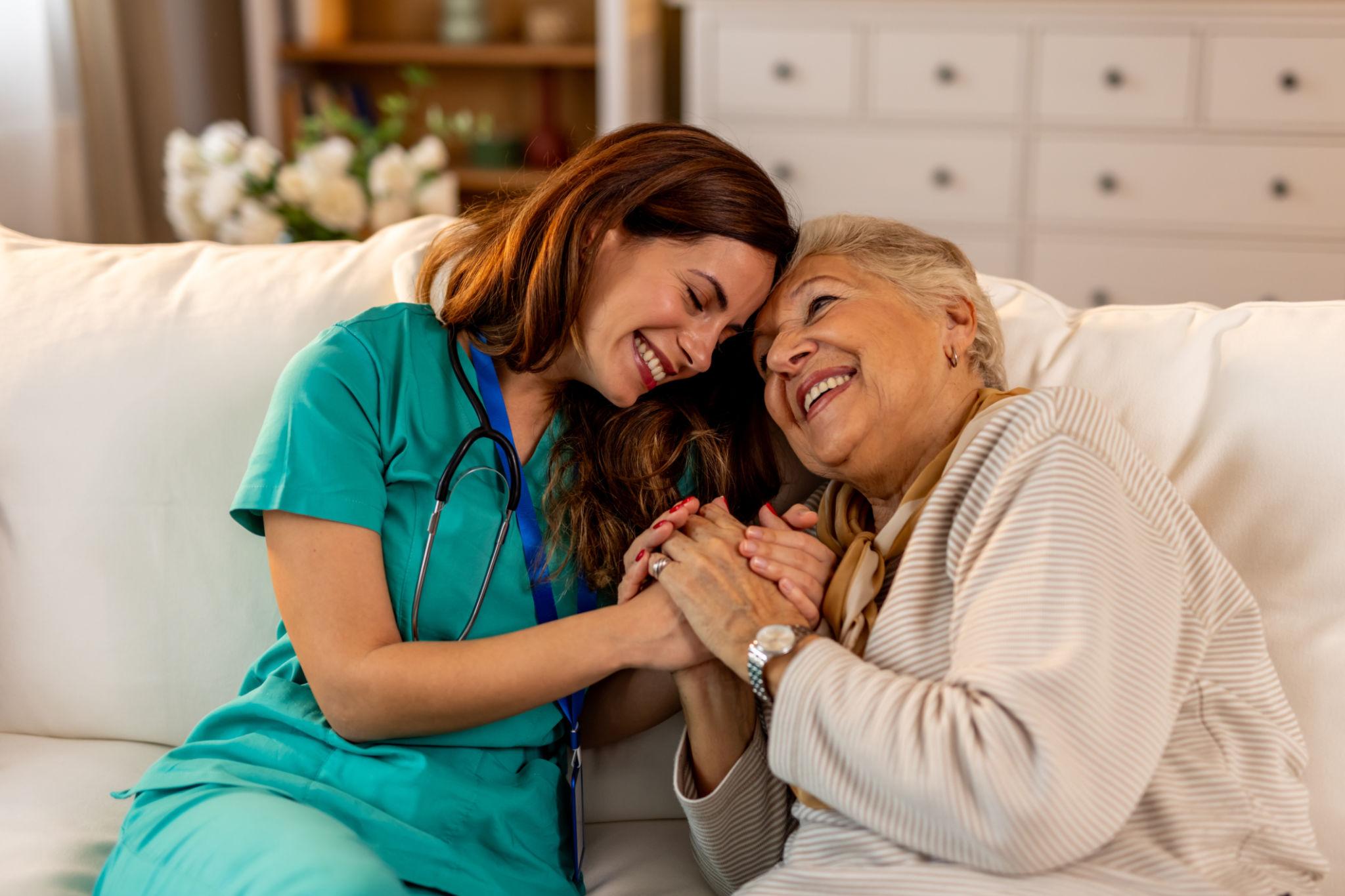 Professional caregiver helping elderly woman at home